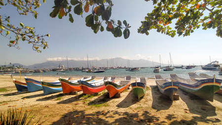 Beautiful traditional canoe at Ilha Bela, Sao Paulo, Brazil. Amazing beach, landscape and boats with different colorsの写真素材