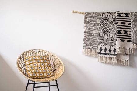 Stylish carpets hanging on the wall and a wooden chain on the sideの写真素材