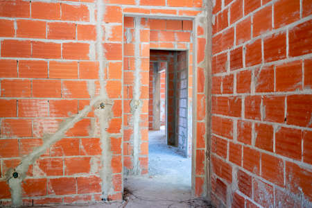 House being build. Interior cement coating and brick walls. Building and renovating house. Under construction site.の写真素材