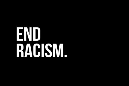 Racism. End Racism. White text on black background representing the need to stop racism