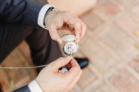 Old pocket watch in the hands of a manの写真素材