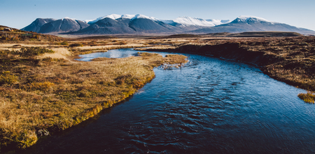 Icelandic landscapes full of green grass, sea and blue sky.の写真素材