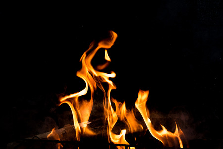 Flames in the fire of a red and yellow barbecue.の写真素材