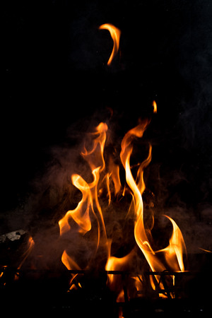 Flames in the fire of a red and yellow barbecue.の写真素材