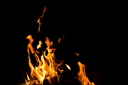 Flames in the fire of a red and yellow barbecue.