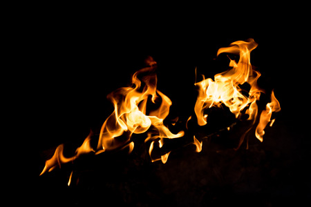 Flames in the fire of a red and yellow barbecue.