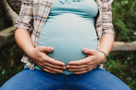 Pictures of the belly of pregnant women in nature with natural background