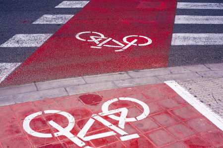 Signs and bike lane markings painted on the asphalt of the streets of an urban city