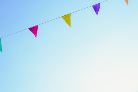 Colorful pennants with sky background to place textの写真素材