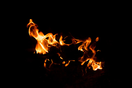 Flames in the fire of a red and yellow barbecue.