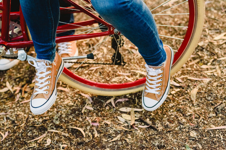 Couple of lovers with green sneakers and jeans standing next to a vintage bicycle