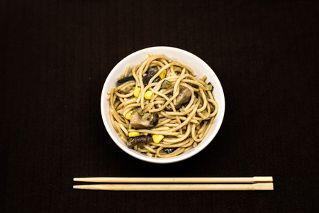 Plate of asian noddles in a white round bowl with chopsticksの写真素材