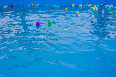 colored balls floating in a poolの写真素材