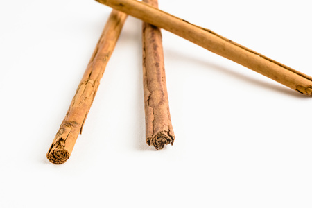 Stack of cinnamon sticks on white background and spaceの写真素材