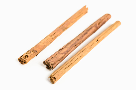 Stack of cinnamon sticks on white background and space