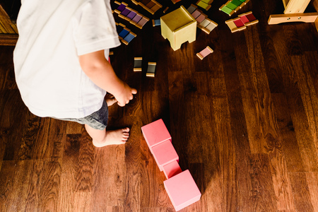 Children playing with pink tower in a Montessori classの写真素材
