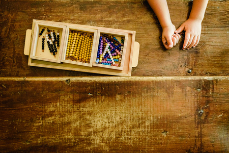 Hands of a child manipulating educational materials to learn to count in a Montessori classroom.の写真素材