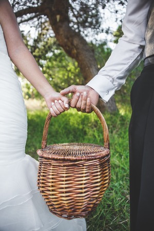 Bride and groom holding a picnic basket.の写真素材
