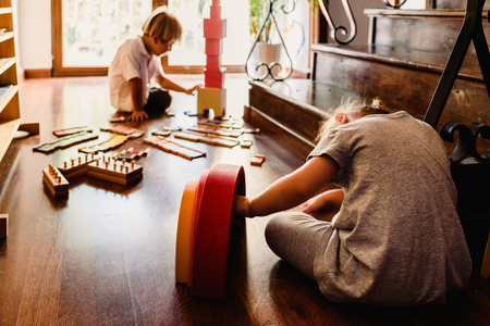Children playing with pink tower in a Montessori classの写真素材