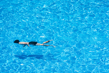 Children diving in a pool in summerの写真素材