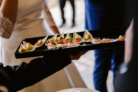 Tasty wedding appetizers served by waiters to the guestsの写真素材