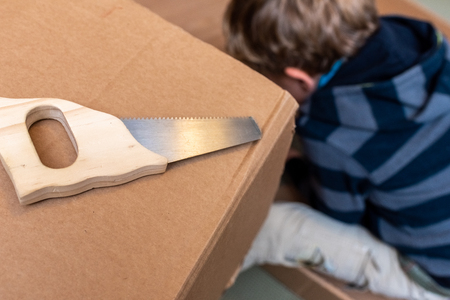 Child playing with a real carpenter saw.の写真素材