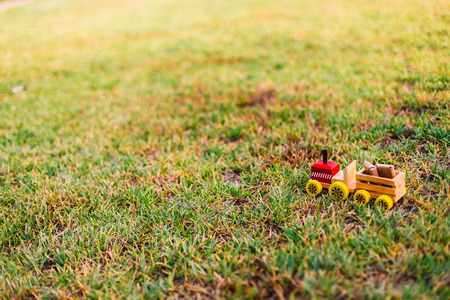 Wooden toy truck transporting packages through the lawn or nature, lots of empty space for text copy space.の写真素材