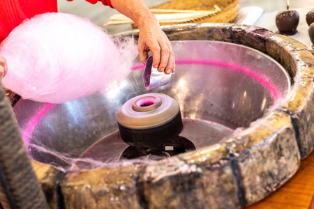 Preparation of a Candy Cotton Cloud at a fair for some children by a cook.の写真素材