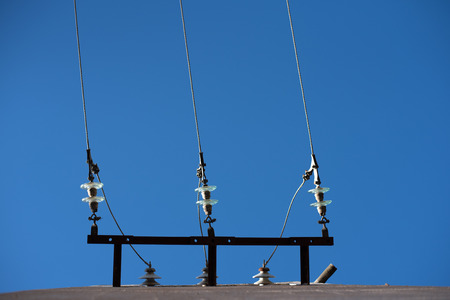 Electric cables seen from below with blue sky background.