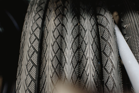 New bicycle tires hanging in a rack of a bicycle workshop