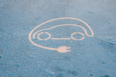 Sign painted on the floor of a parking lot for electric cars.の写真素材