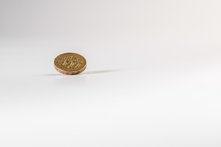 1 British pound coin falling on white background, isolatedの写真素材