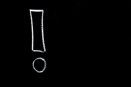 Exclamation mark, drawn by hand on a black chalkboardの写真素材