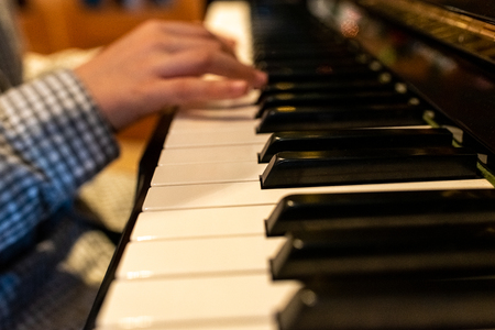 Child's hands playing the keys of a piano during Christmas.の写真素材