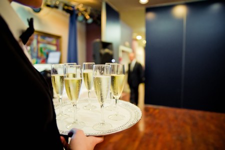 Waiters serving glasses of champagne to the guests at a party.の写真素材
