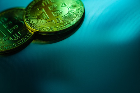 Two bitcoin coins isolated on technological blue background.