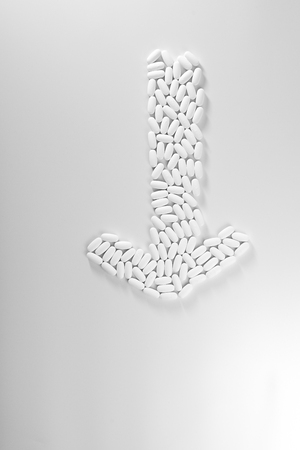 Direction arrow made with pills isolated on white background, medicine concept