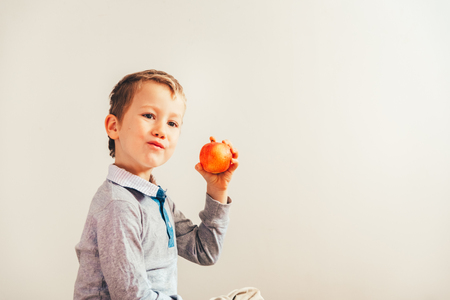 Child ready to eat an apple at a bite, isolated on white background with copy space.の写真素材