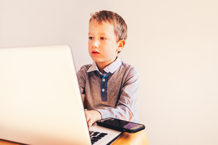 Child working with his computer in his business, concentrated typing to succeed, funny image.の写真素材