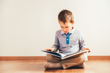 Portrait of boy interested in reading a book.の写真素材
