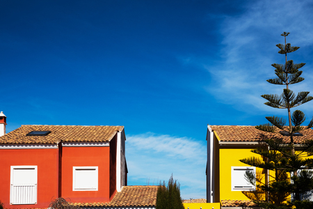 Houses with facade of Mediterranean colors and intense blue sky.の写真素材
