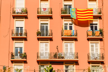 Valencia, Spain - March 16, 2019: Facade of a building with a large SeÃ±era, flag of Valencia, hanging from a balcony during the celebration of the Fallas.のeditorial素材