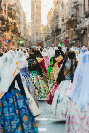 Valencia, Spain - March 17, 2019: Fallera Commission parading down Calle de la Paz, seen from behind, during the Fallas offering.のeditorial素材