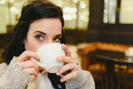 Pretty brunette woman drinking coffee in Vienna, European city, during a trip.の写真素材