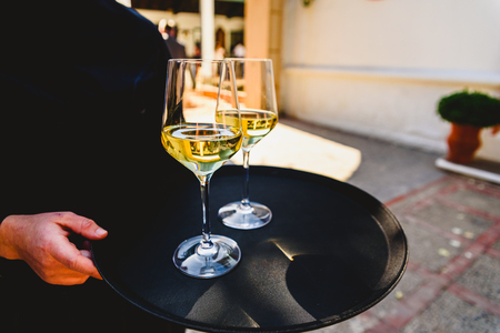Tray with two glasses of champagne held by a waiter.の写真素材