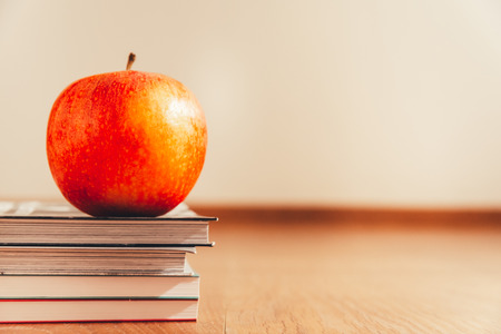 Apple over books isolated on white background and wooden floor, concept of healthy life.の写真素材