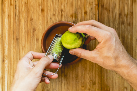 Hands of man scratching a lemon, peeling.の写真素材