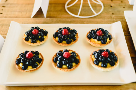 juicy red fruits prepared on puff pastry tarts and on puff pastry tartlets