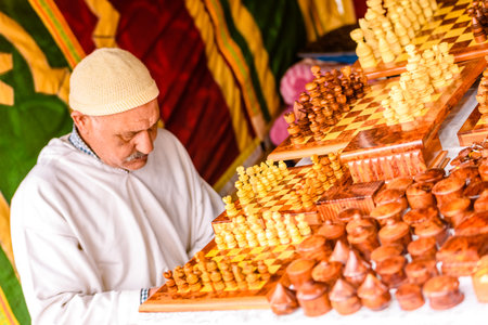 Valencia, Spain - January 27, 2019: Moroccan Arab craftsman selling pieces and chess boards made of wood by hand in a medieval market.のeditorial素材
