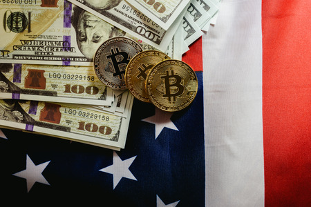 Bitcoin physical coins on American flag background with dollars in the background.の写真素材